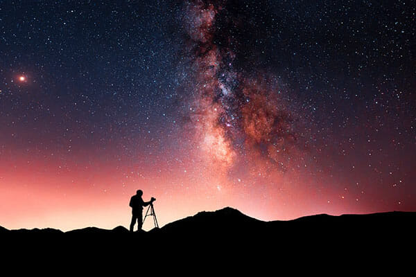 Beautiful,Starry,Night,Landscape.,A,Silhouette,Of,A,Photographer,Stands Night Sky Photography Tutorial by iPhotography.com