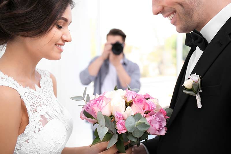 a wedding photographer taking a photo of a bride and groom