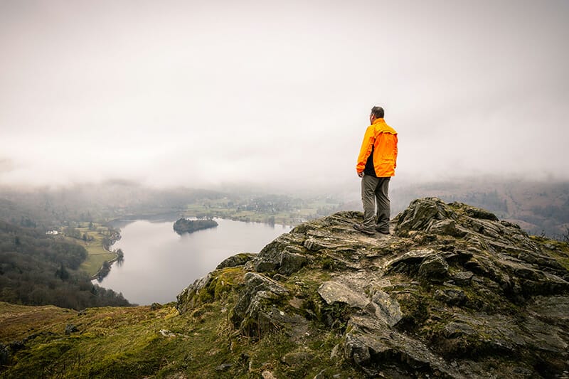 Chris Sale landscape photographer stood atop a mountain looking over a lake in the Lake District