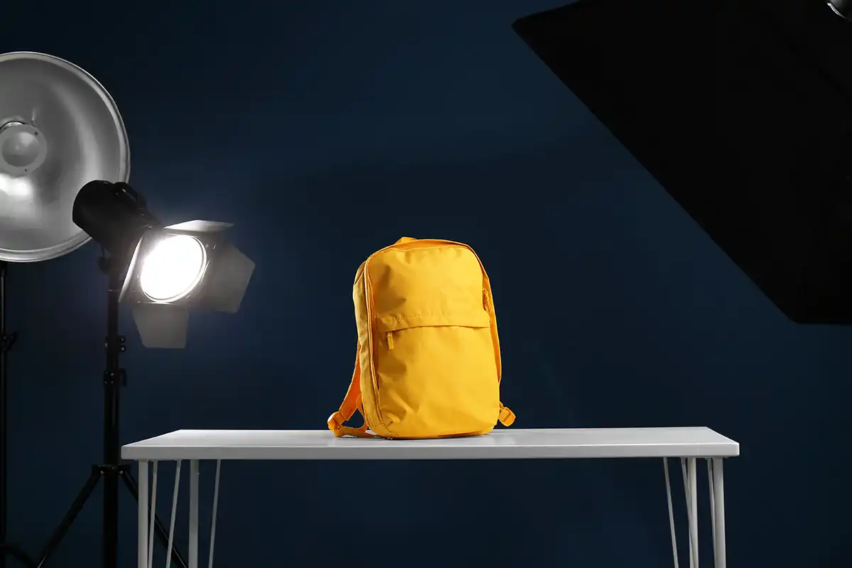 A yellow rucksack on a table surrounded by photography lights