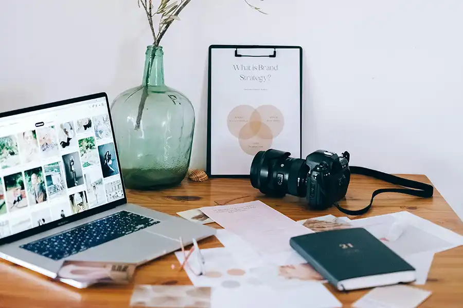 a camear on a desk next to a laptop. business branding
