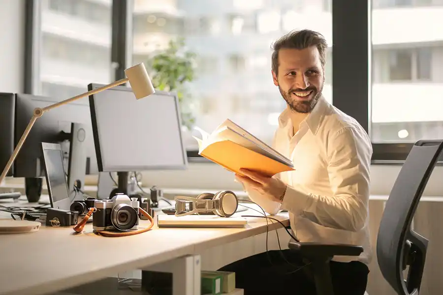 man sat at a desk reading a workbook