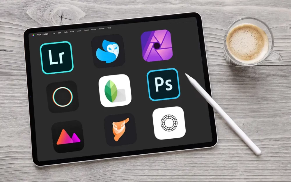 an android tablet with app logos on. there is a stylus and a latte drink next to the tablet