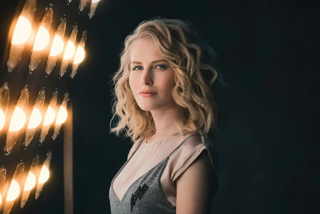 Portrait of a blonde model stood next to lights