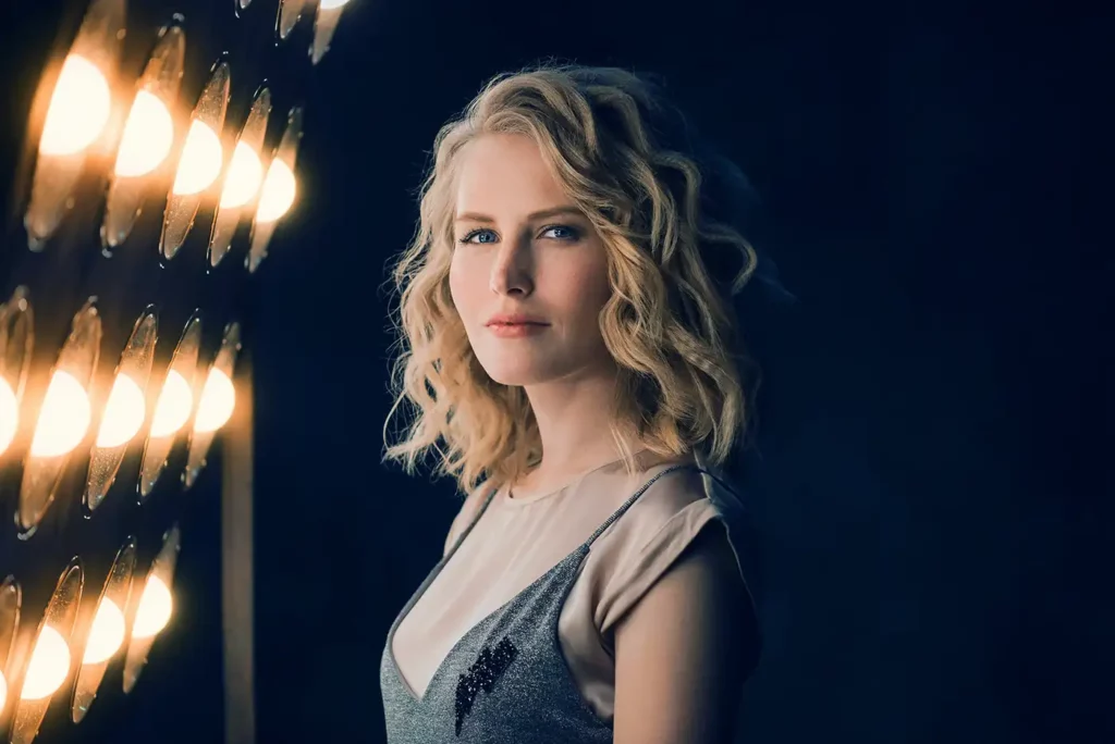Portrait of a blonde model stood next to lights
