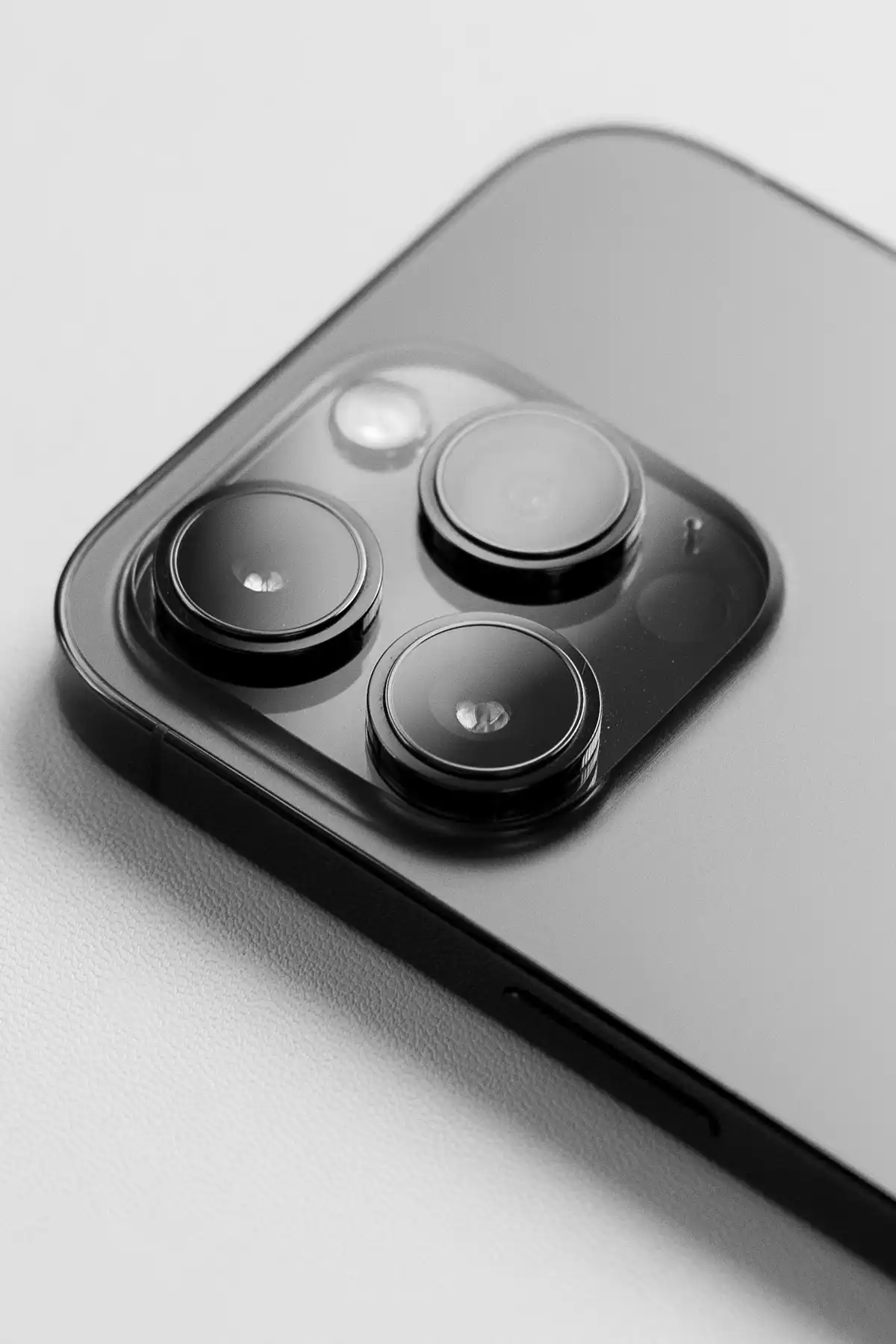 An iPhone face down on a table with the three cameras