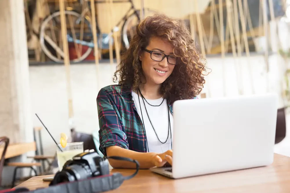 a lady sat at a laptop smiling