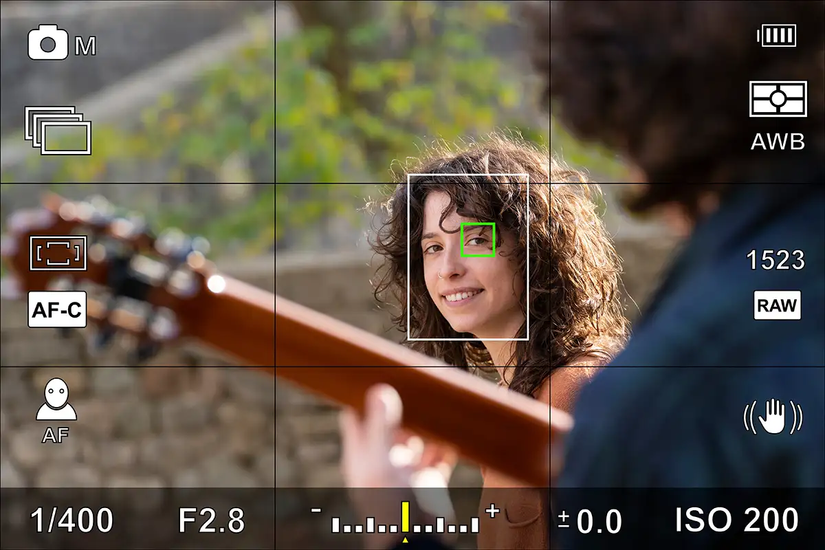 lady smiling at a guitarist through a camera screen