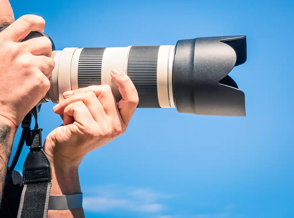 man holding camera lens