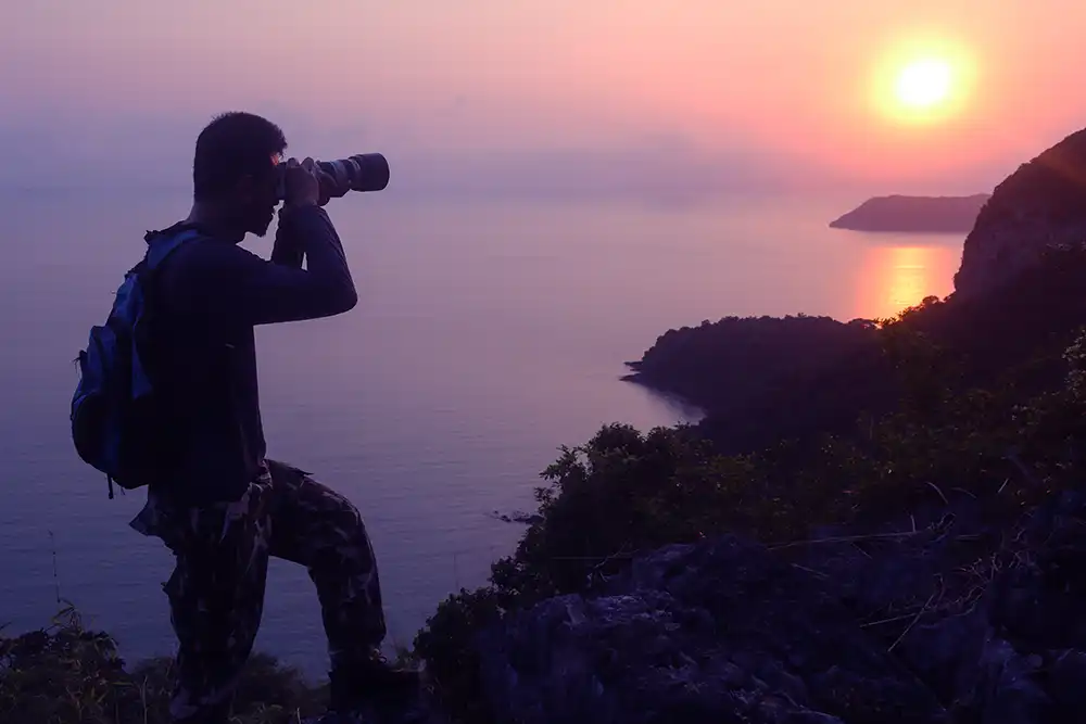 man taking photo of sunset