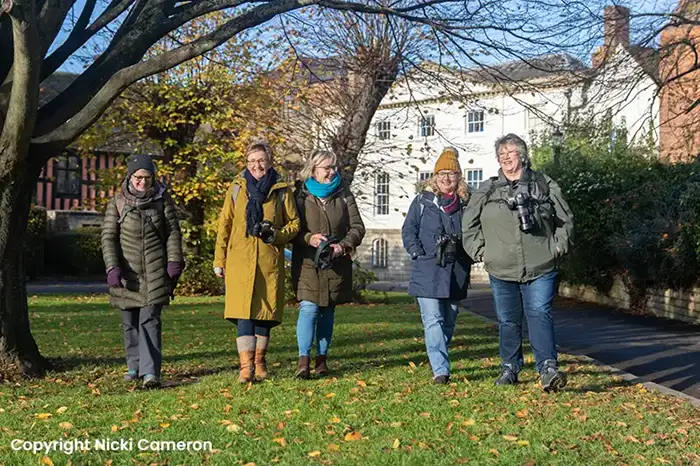 5 female photographers walking through a park by Nicki Cameron