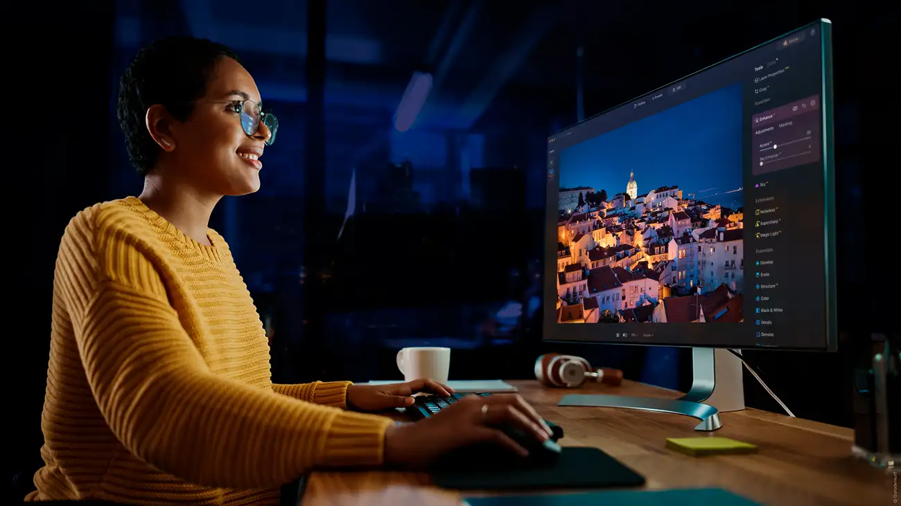 Lady at a computer editing photos at night