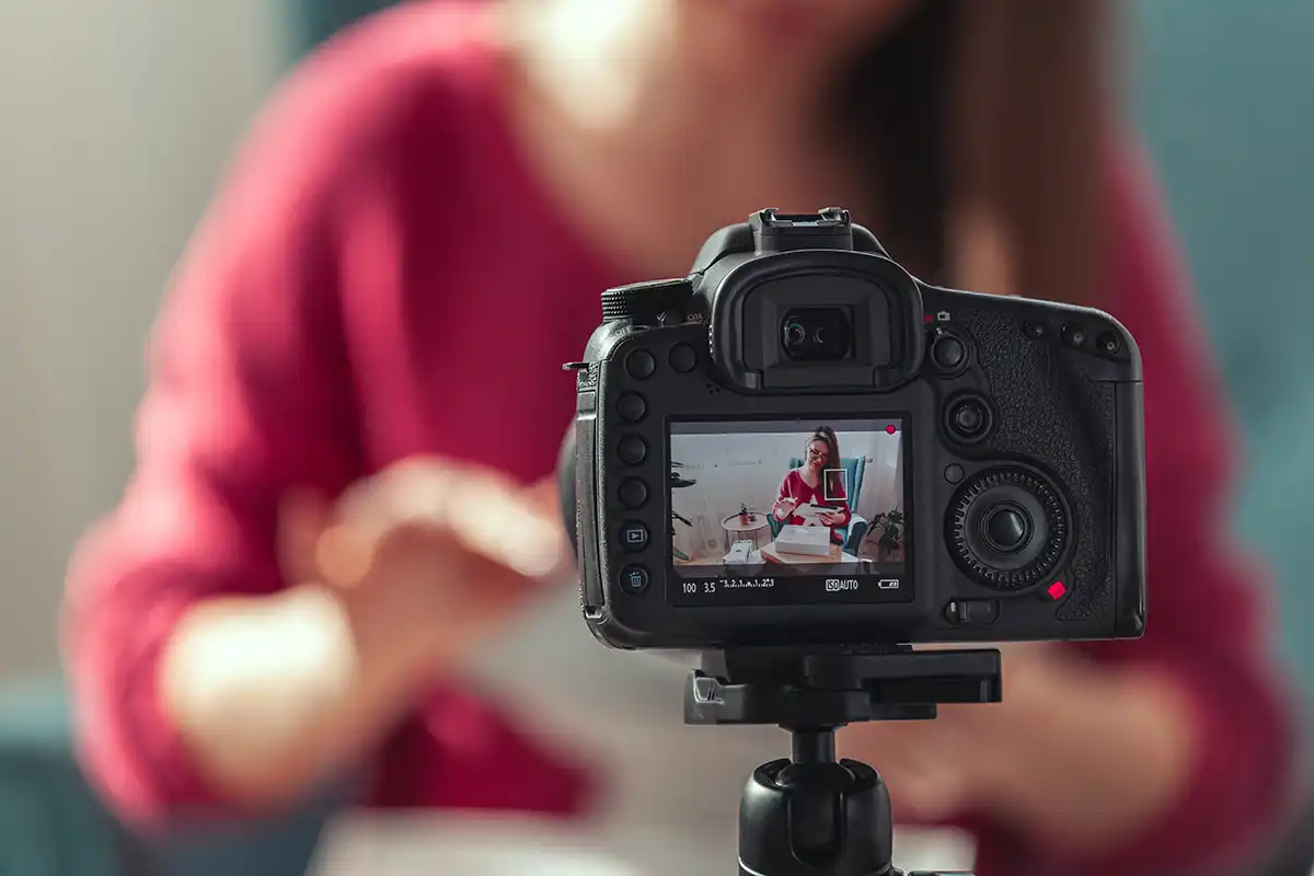Person in red jumper talking to a camera