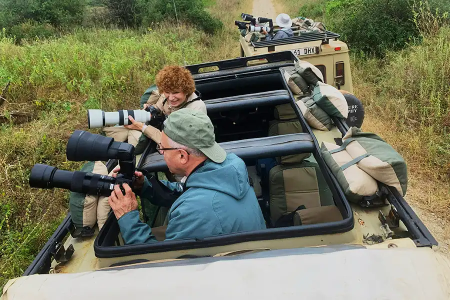 Photographers taking photos out of the top of open roof jeeps on Safari in Kenya