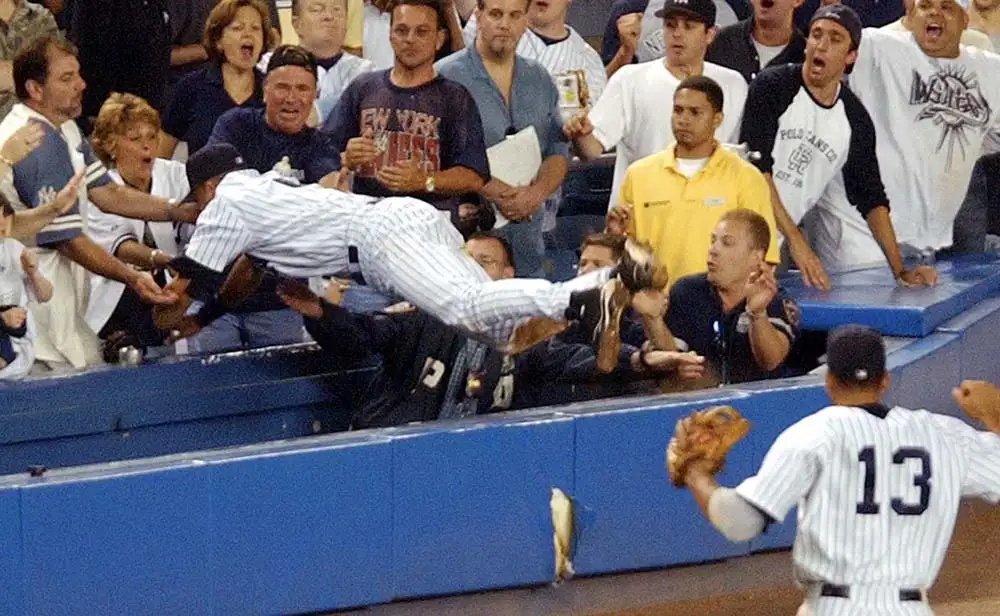 Baseball jumping into the crowd to catch a ball