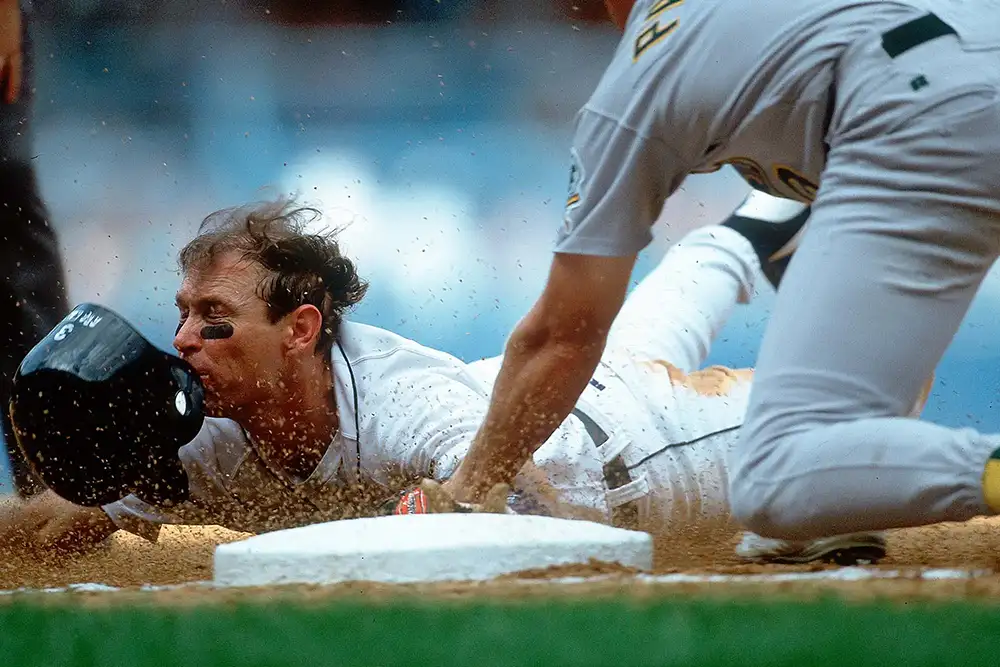 Baseball player jumping on a base and helmet has come off. Copyright Walter Iooss Jr